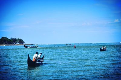 Boats sailing in sea against blue sky