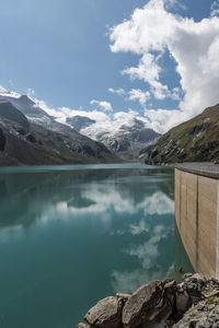 Scenic view of lake by mountains against sky