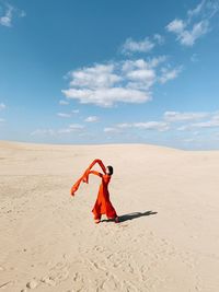 Woman on sand at beach against sky