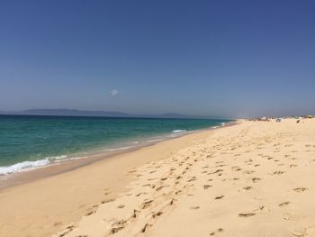 Scenic view of beach against blue sky