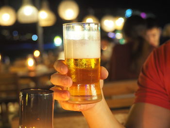 Close-up of hand holding beer glass