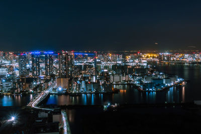 High angle view of illuminated buildings against sky at night