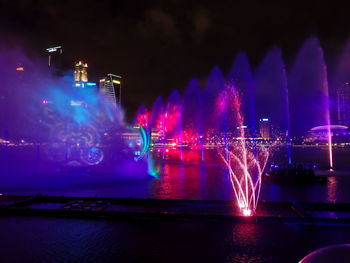 Illuminated fountain in city at night