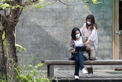 Side view of woman sitting on rock