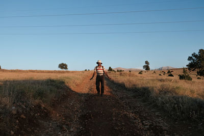 Rear view of woman walking on field