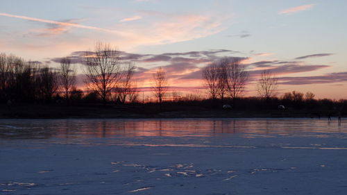 Scenic view of lake against sky at sunset