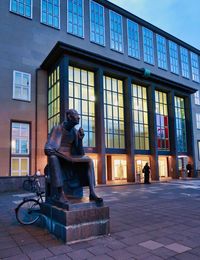 Statue against building in city