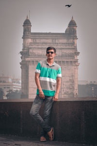 Full length portrait of young man standing in city