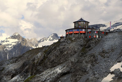 Built structure on snowcapped mountain against sky