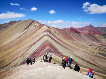 People on mountain against sky