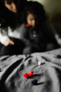 Close-up of red and woman relaxing on bed at home