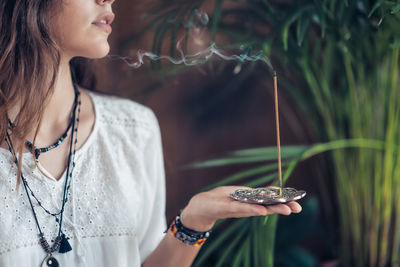 Young woman holding burning incense