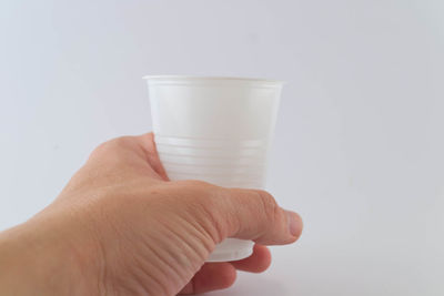 Midsection of person holding ice cream against white background