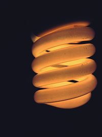 Close-up of illuminated lamp over black background