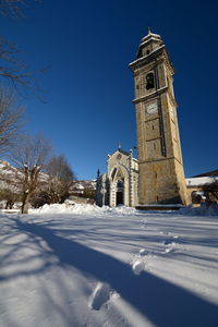 Church by building against clear sky during winter