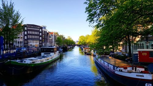 Canal amidst buildings in city against sky