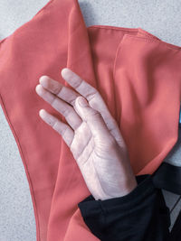 Cropped hand of person on red fabric