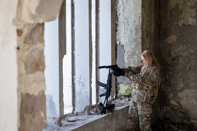 Caucasian military woman in a destroyed building.