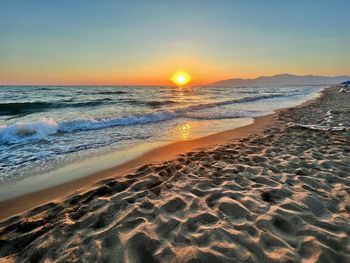 Scenic view of beach against sky during sunset