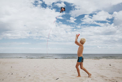 Boy on beach playing with kite
