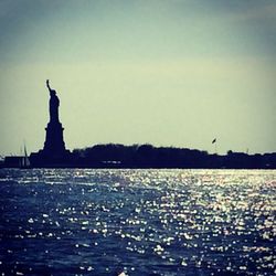 Statue in sea against clear sky