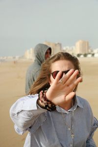 Woman gesturing while standing at beach