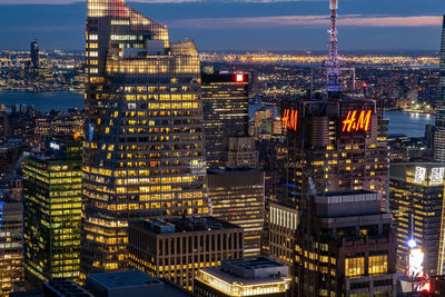 Illuminated buildings in city against sky at night