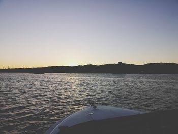 Scenic view of lake against clear sky during sunset