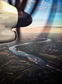 Close-up of airplane flying over landscape against the sky