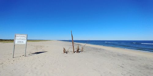 Scenic view of beach against clear blue sky