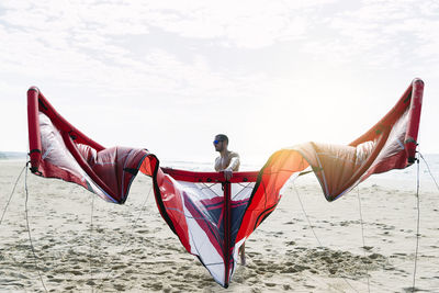 Low angle view of woman standing on beach against sky