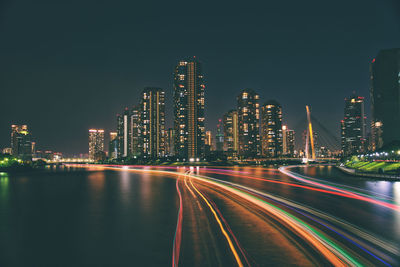 Illuminated light trails on city buildings at night