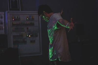 Man with illuminated lights standing at night