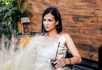 Portrait of an attractive young woman holding a drink in her hand.