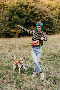 Rear view of man with dog on field