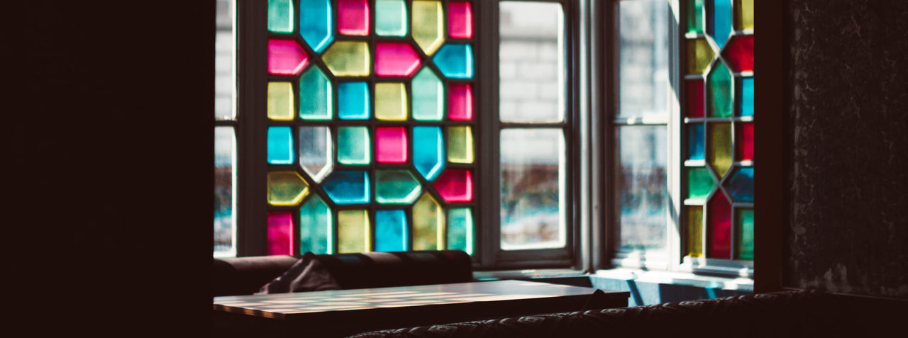 MULTI COLORED GLASS WINDOWS ON TABLE