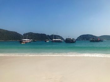 Sailboats on sea against clear sky