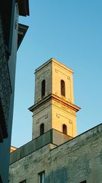 Low angle view of bell tower against blue sky