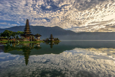 Scenic view of lake by building against sky