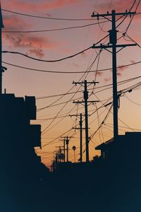 Low angle view of silhouette cables against sky during sunset