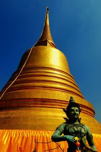 Low angle view of statue against temple against clear sky