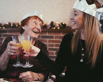 Happy females toasting juice glasses in party