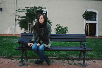 Portrait of young woman sitting at park