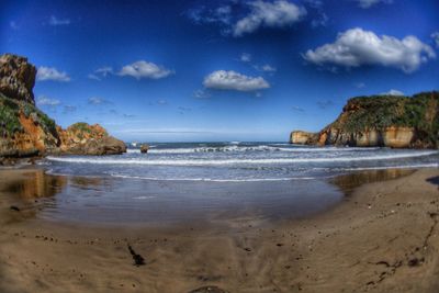 View of calm beach against blue sky