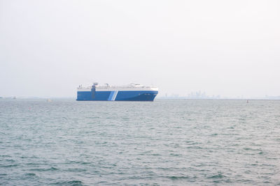 Boat sailing in sea against clear sky