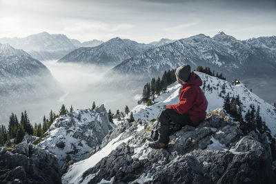 Man sitting on snowcapped mountain