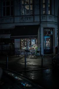 Illuminated street amidst buildings in city at night