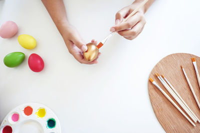 High angle view of hand holding ice cream on table