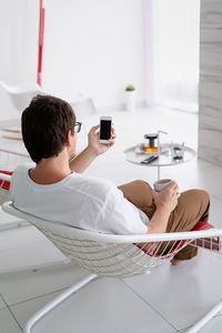 Man using mobile phone while sitting on table