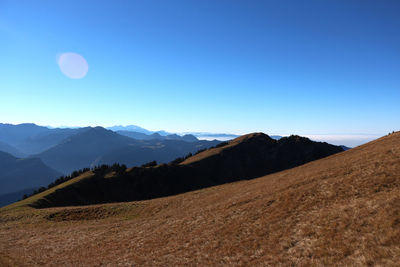 Scenic view of mountains against blue sky